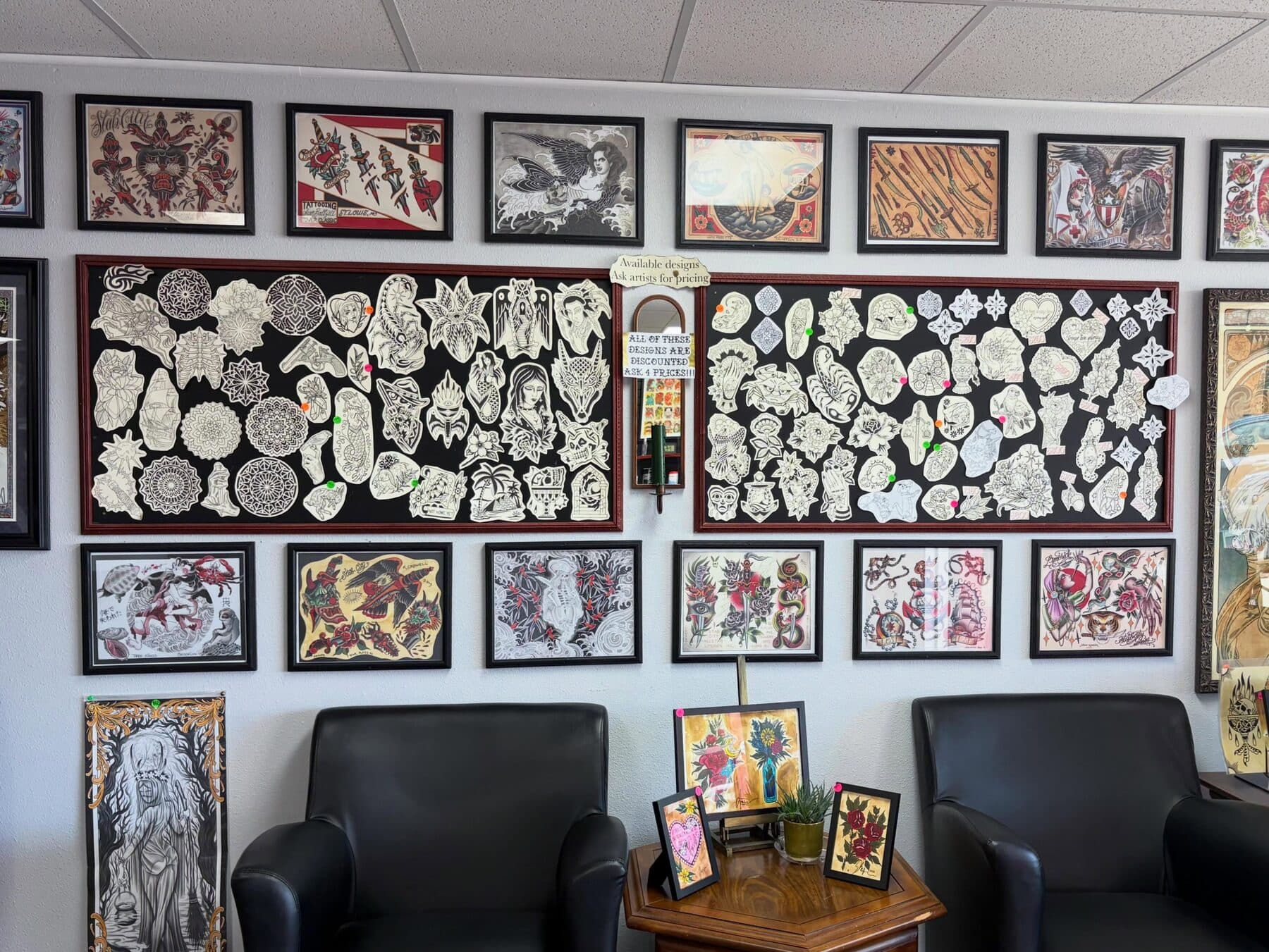 Flash designs and framed artwork covering the walls at Red Letter Tattoo